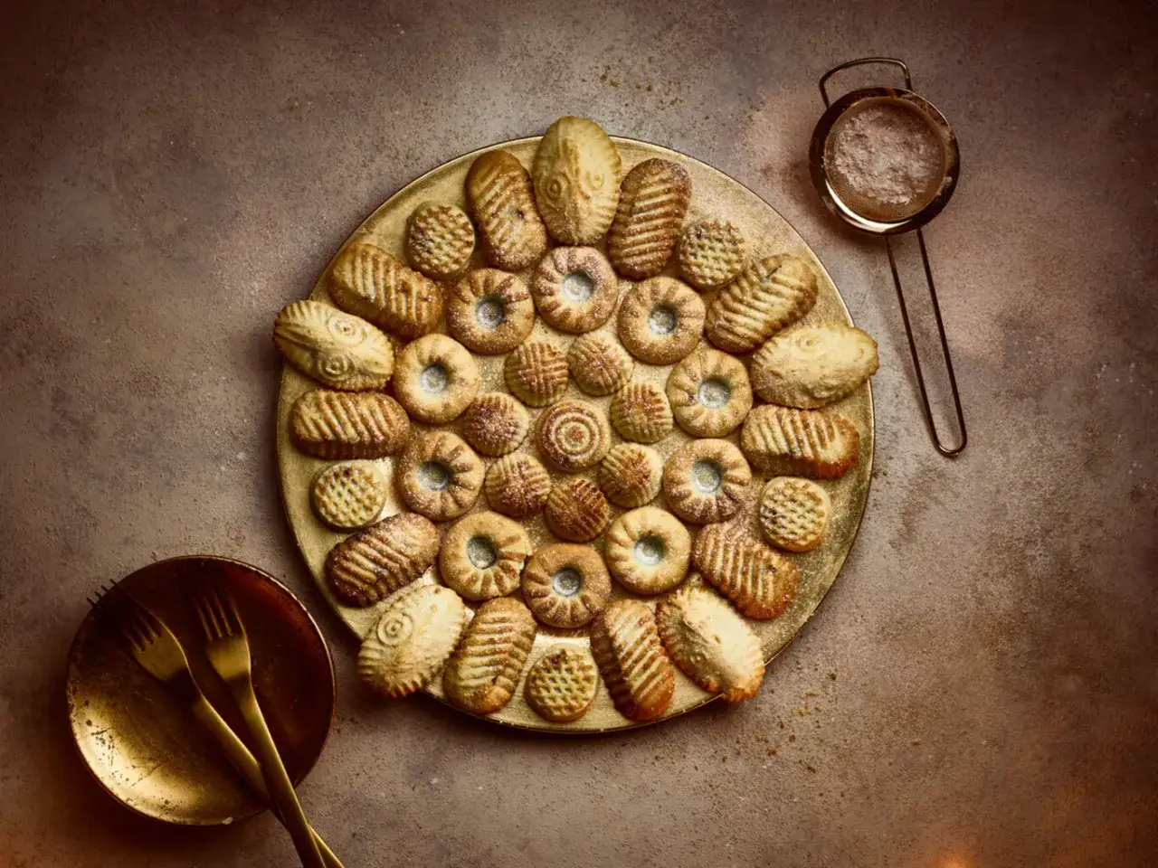 Ein goldener Teller voller Maamoul-Kekse, bereit zum Genießen. Dieses Maamoul-Rezept ist ein Fest für die Augen und den Gaumen.