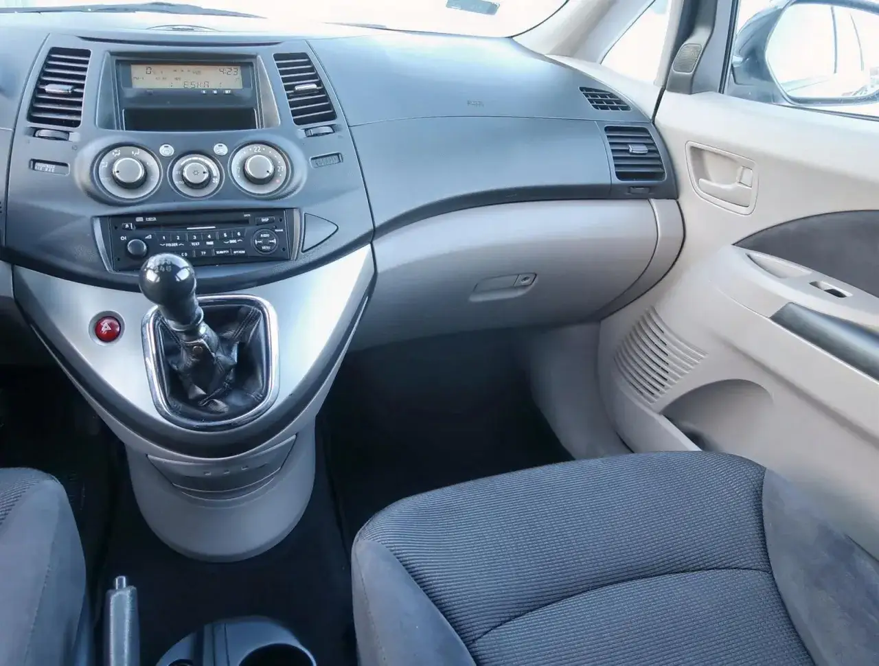 Wnętrze Mitsubishi Grandis: widok na deskę rozdzielczą, dźwignię zmiany biegów i siedzenie pasażera.