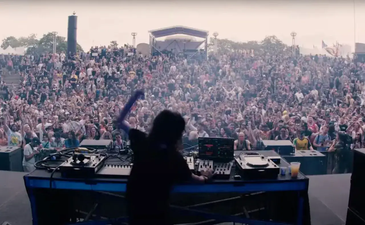 Oscar Mulero sul palco, con una folla immensa che balla sotto un cielo nuvoloso.