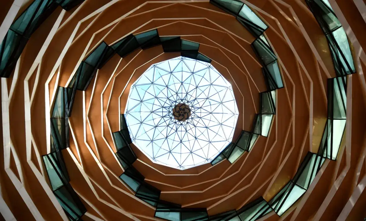 Ein faszinierender Blick nach oben auf eine moderne Kuppel mit Holzelementen und Glas. Ein architektonischer Geheimtipp in Istanbul, der zum Staunen einl&auml;dt.