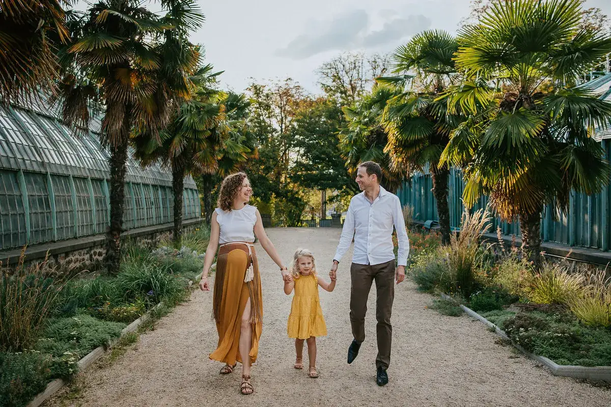 Une famille profite d'une promenade ensoleillée dans un jardin botanique, une scène de photographie lifestyle capturant leur bonheur.