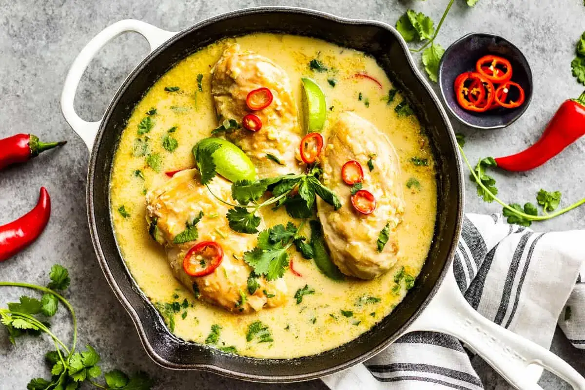 Aromatyczny kurczak po tajsku w kremowym sosie kokosowym, ozdobiony chili i kolendrą.