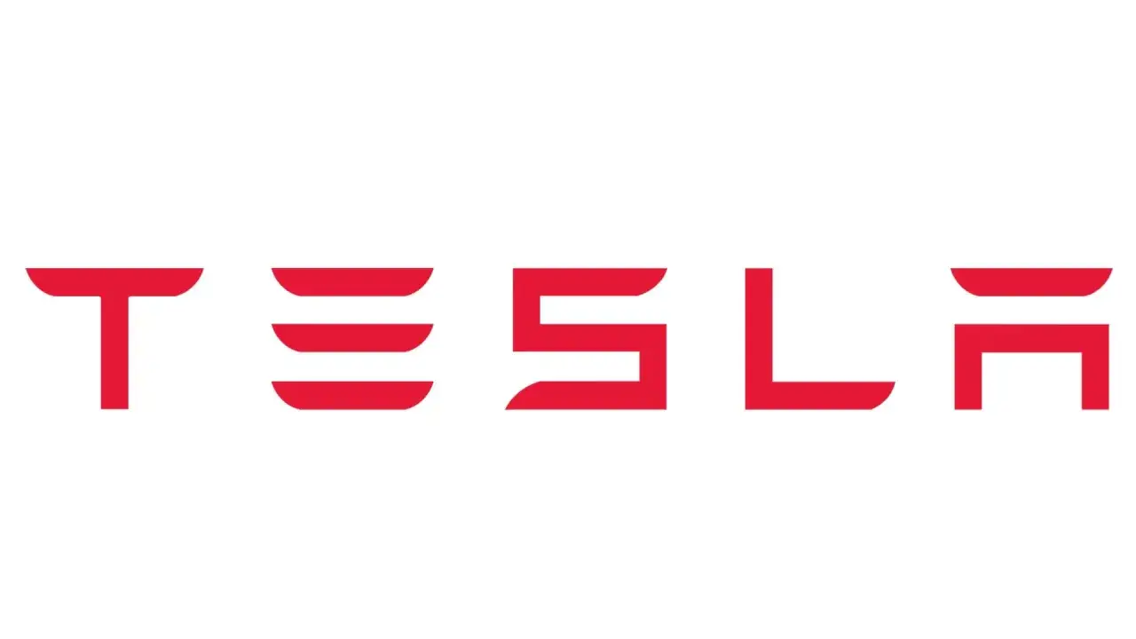 Czerwony napis TESLA na białym tle. Tak wygląda znaczek Tesli, symbol innowacji i przyszłości motoryzacji.