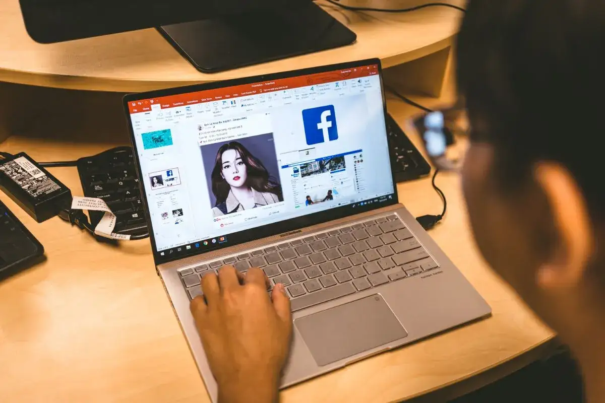 Osoba korzysta z laptopa, na ekranie widać Facebooka i instrukcję, jak zmienić datę urodzenia na FB.