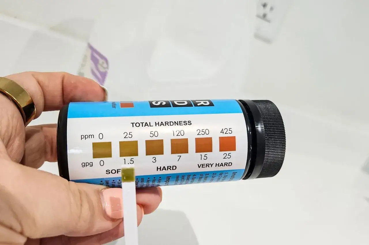 Bandelette r&eacute;active pour le calcul de la duret&eacute; de l'eau. La couleur verte indique une eau douce.
