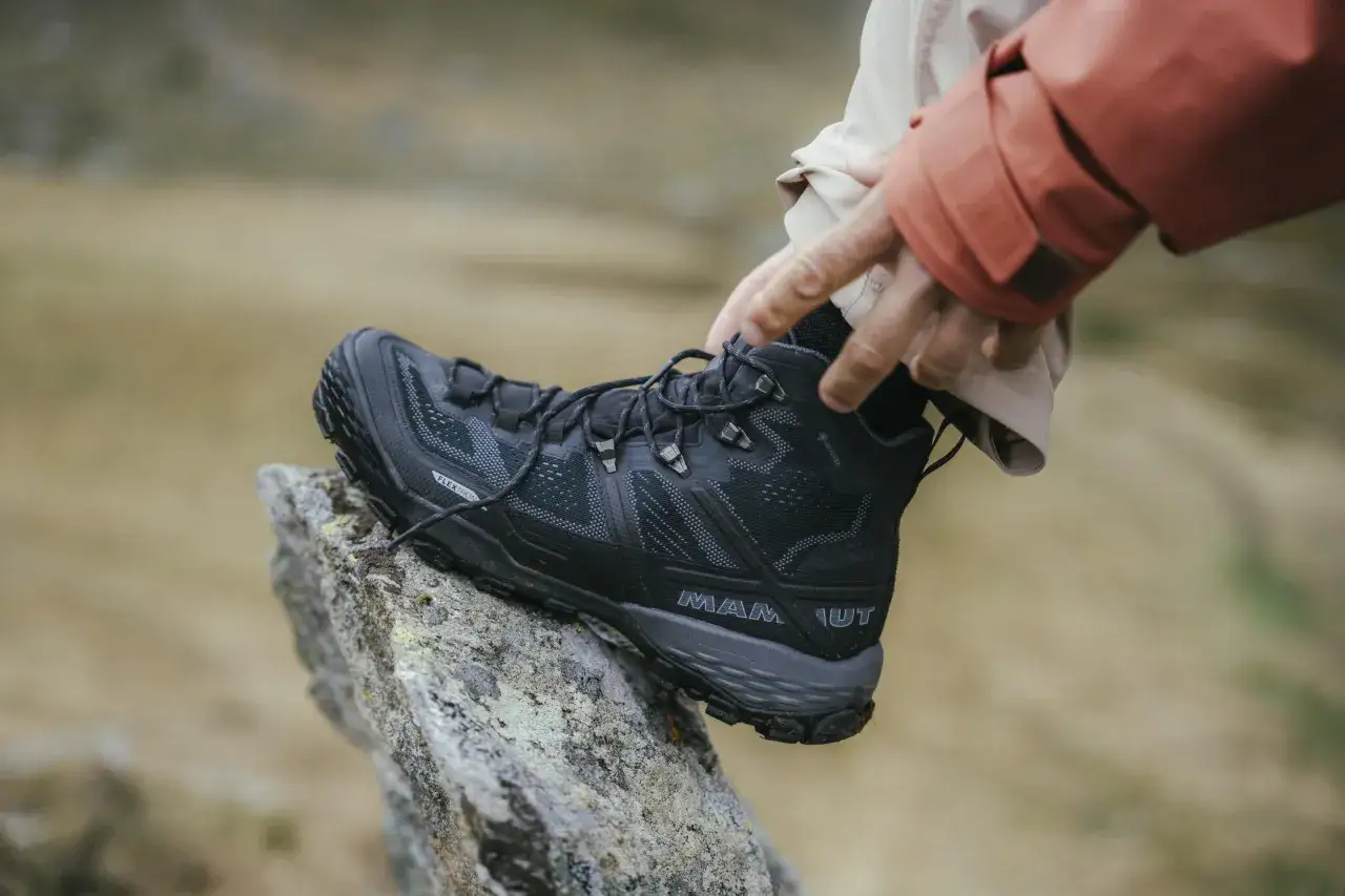 Schwarzer, robuster Wanderschuh von Mammut mit Gore-Tex, der auf einem Felsen ruht. Perfekt f&uuml;r jedes Abenteuer, welche Wanderschuhe sind das wohl?