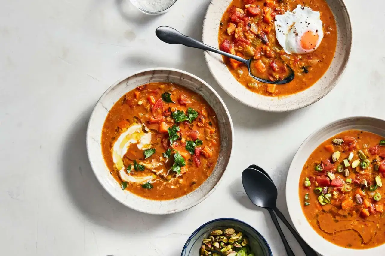 Värmande linsgryta recept med krämig topping, pocherat ägg och pistagenötter. En härlig och mättande måltid.