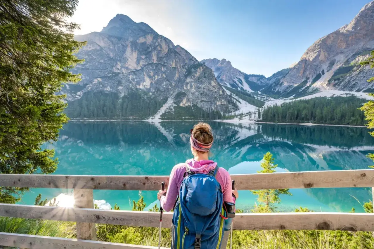 Vandrare njuter av en vacker sommardag vid en turkos sjö i Dolomiterna.