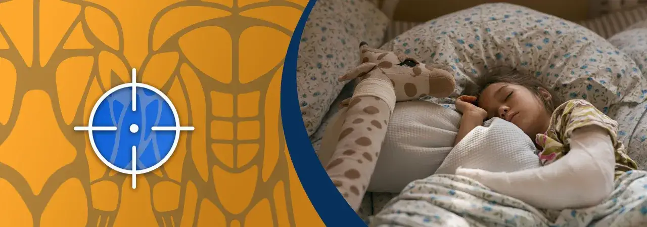 Dziewczynka śpi z ręką w gipsie, przytulając pluszową żyrafę. Dowiedz się, jak spać z ręką w gipsie.