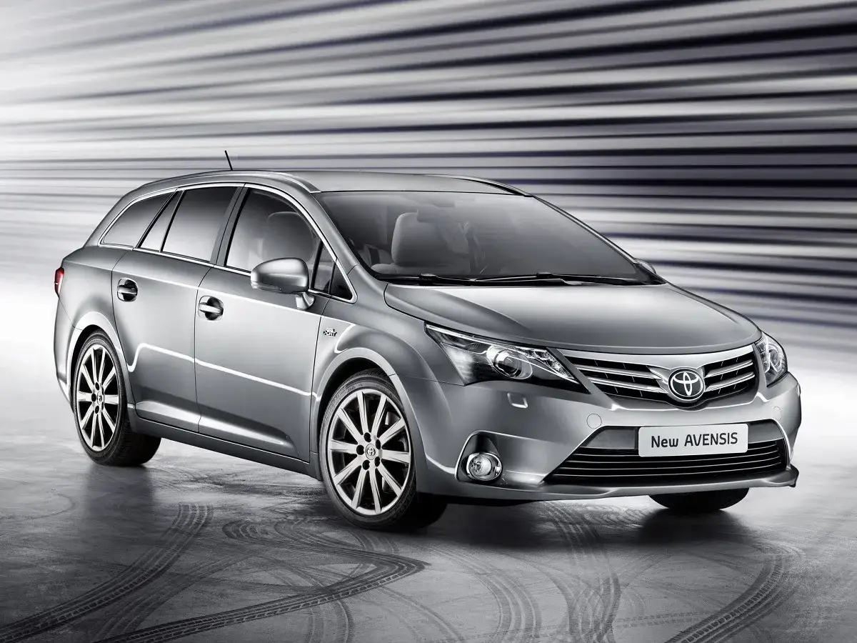 Srebrny kombi Toyota Avensis T27 z przyciemnianymi szybami i felgami aluminiowymi stoi na betonowej posadzce.