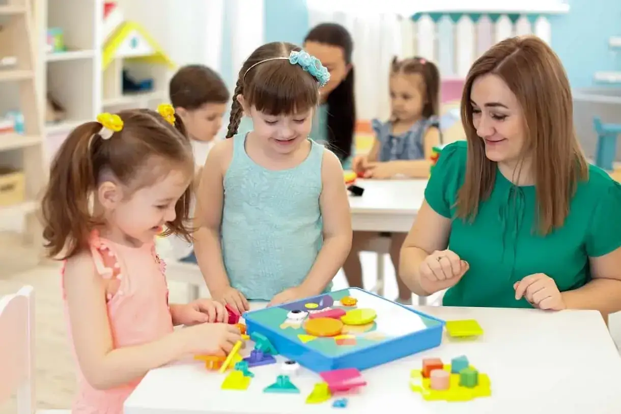Dzieci bawią się klockami w przedszkolu. Zazwyczaj przedszkole trwa 3 lata, od 3 do 6 roku życia.