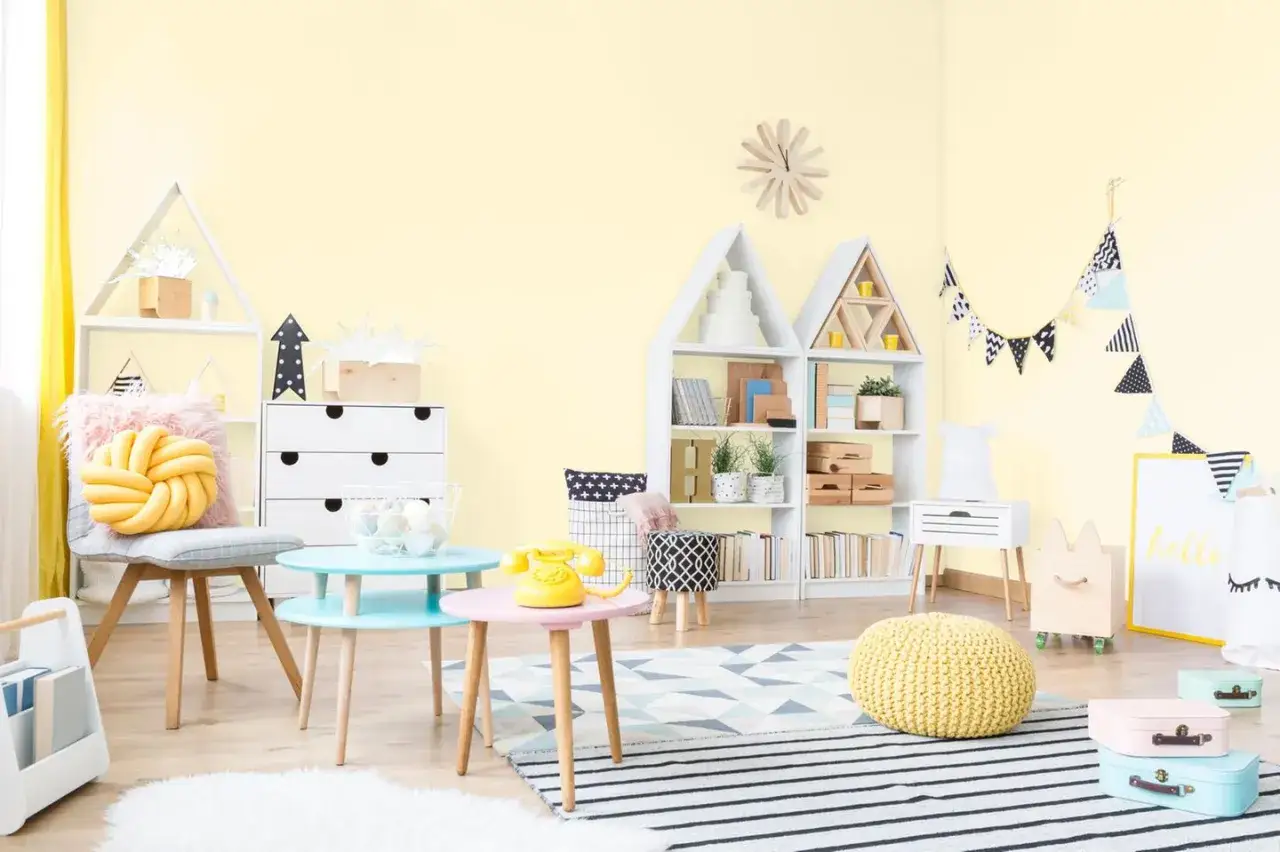Helles Kinderzimmer mit gelben W&auml;nden, Spielzeug und M&ouml;beln. Ein gem&uuml;tliches farbkonzept kinderzimmer.