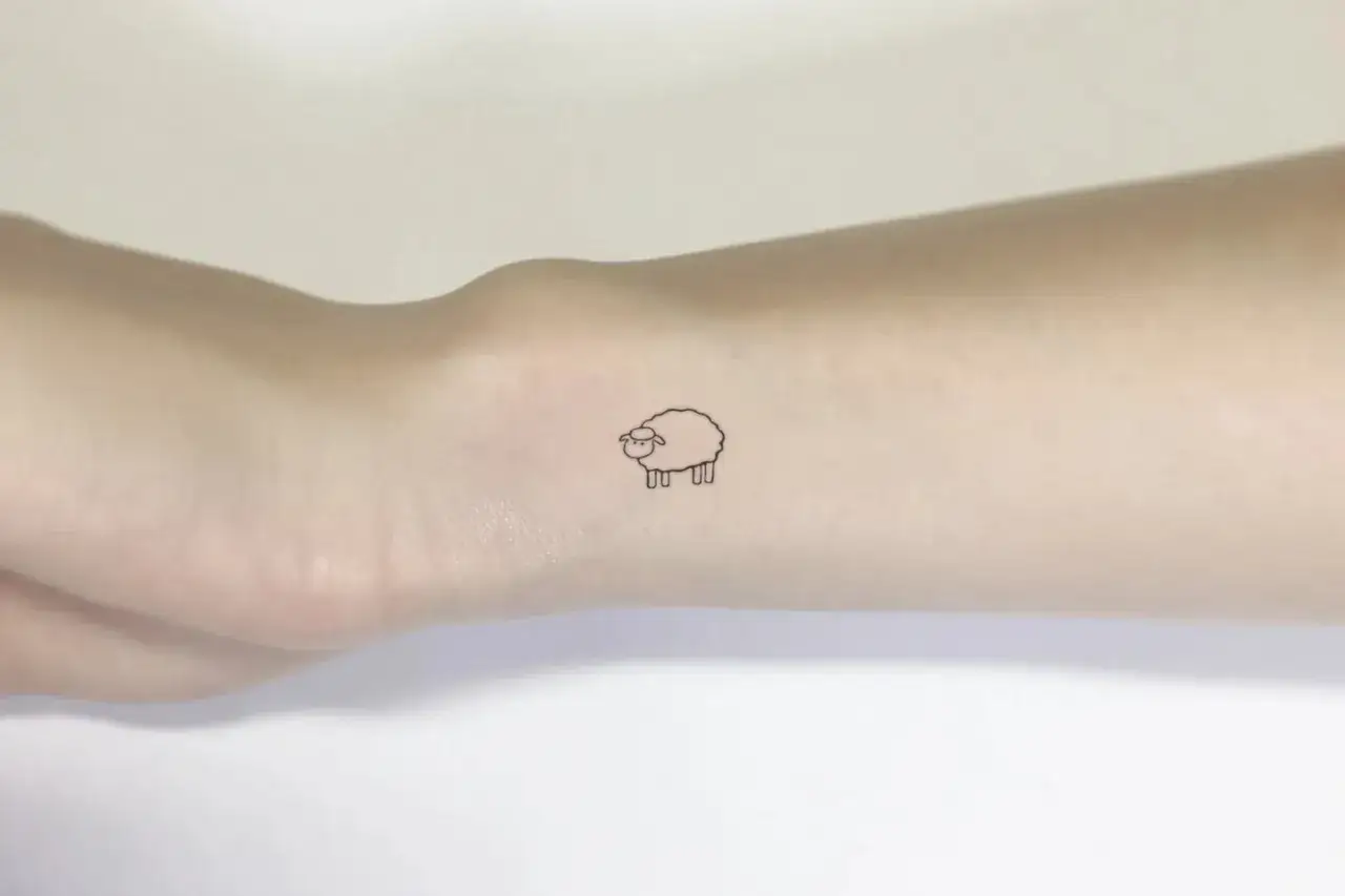 Urocze, male tatuaze z owieczką na nadgarstku.