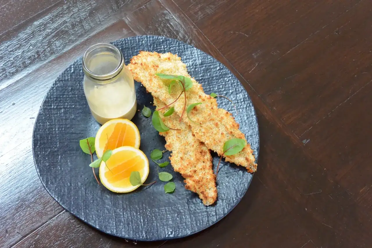 Krispiga fiskfiléer med citronsås, citronklyftor och gröna blad. Perfekt tillagad med ångfunktion ugn för en saftig insida.