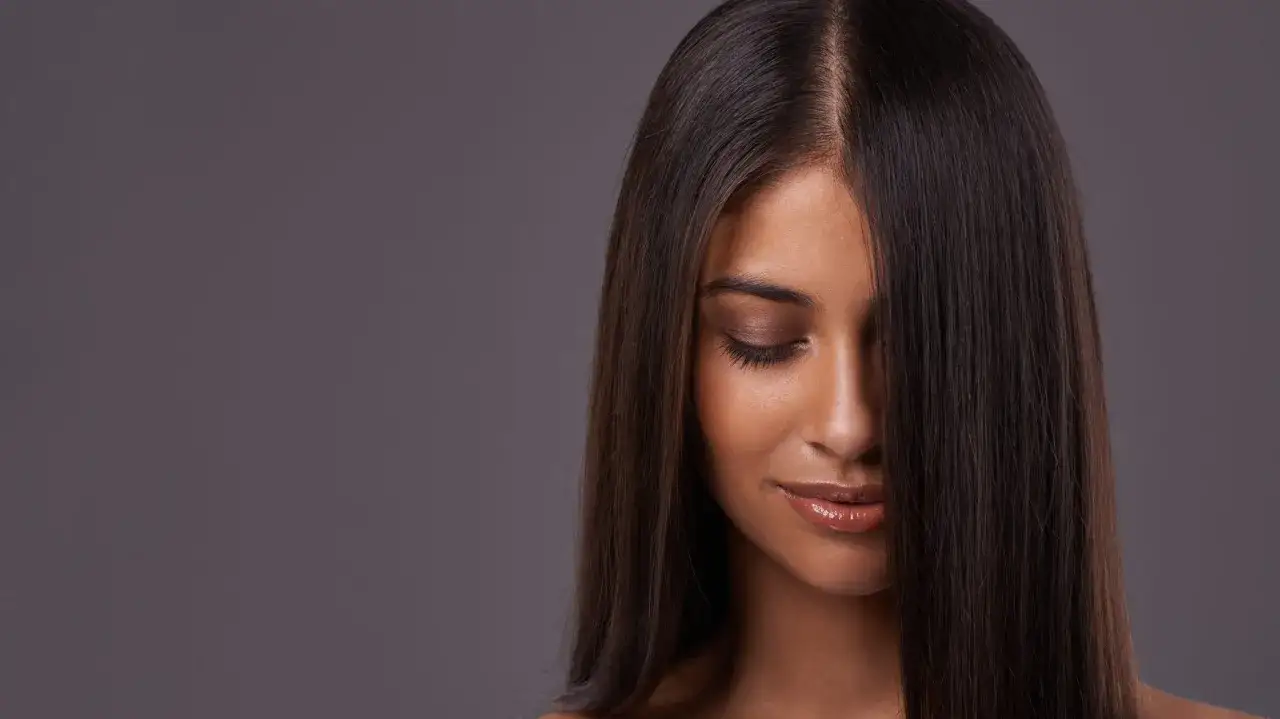 Mujer con cabello oscuro y liso, ideal para quienes buscan aumentar densidad capilar mujer.