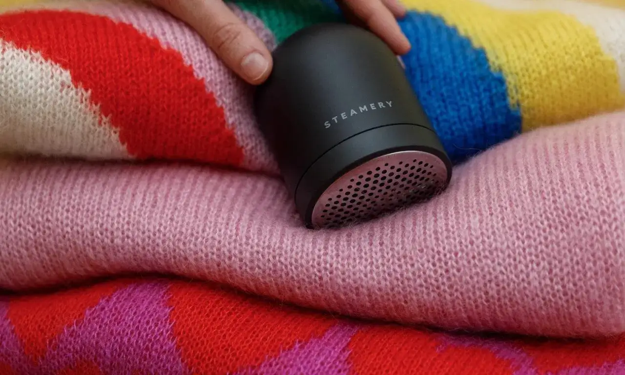 Un appareil pour enlever les bouloches sur un pull en laine color&eacute;. Une solution pour comment enlever de la colle sur un pull en laine.