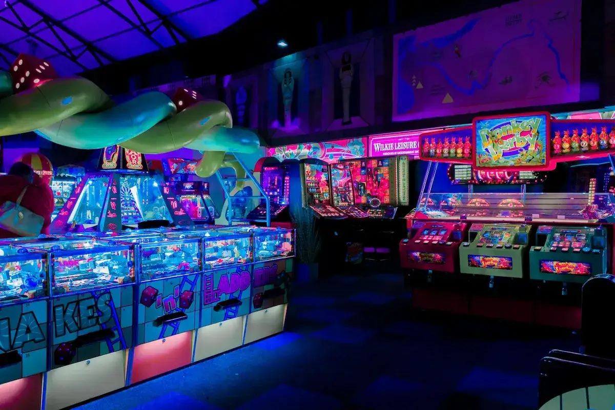 Bunte Spielautomaten und Lichter in einem Arcade-Bereich in Berlin.