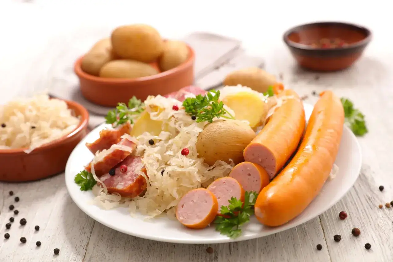 Assiette de choucroute garnie, saucisses, pommes de terre et lardons, un classique des alsace sp&eacute;cialit&eacute;s culinaires.