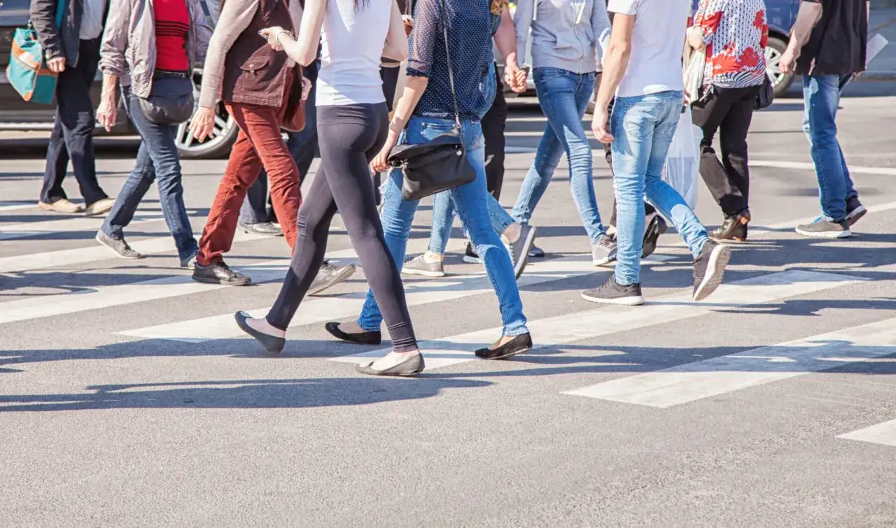 Un groupe de personnes traverse la rue sur un passage piéton, respectant la réglementation marche sur route.