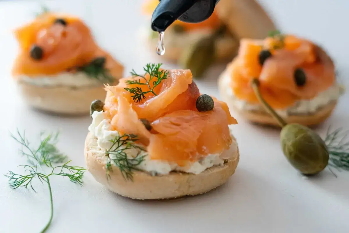 Goutte de sauce sur un bagel saumon fum&eacute;, fromage frais, c&acirc;pres et aneth. Un d&eacute;lice !