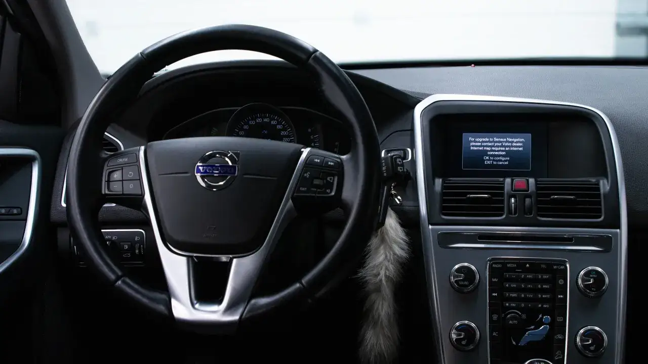 Wnętrze Volvo z ekranem informującym o potrzebie aktualizacji map. Wymagana jest łączność internetowa do konfiguracji.