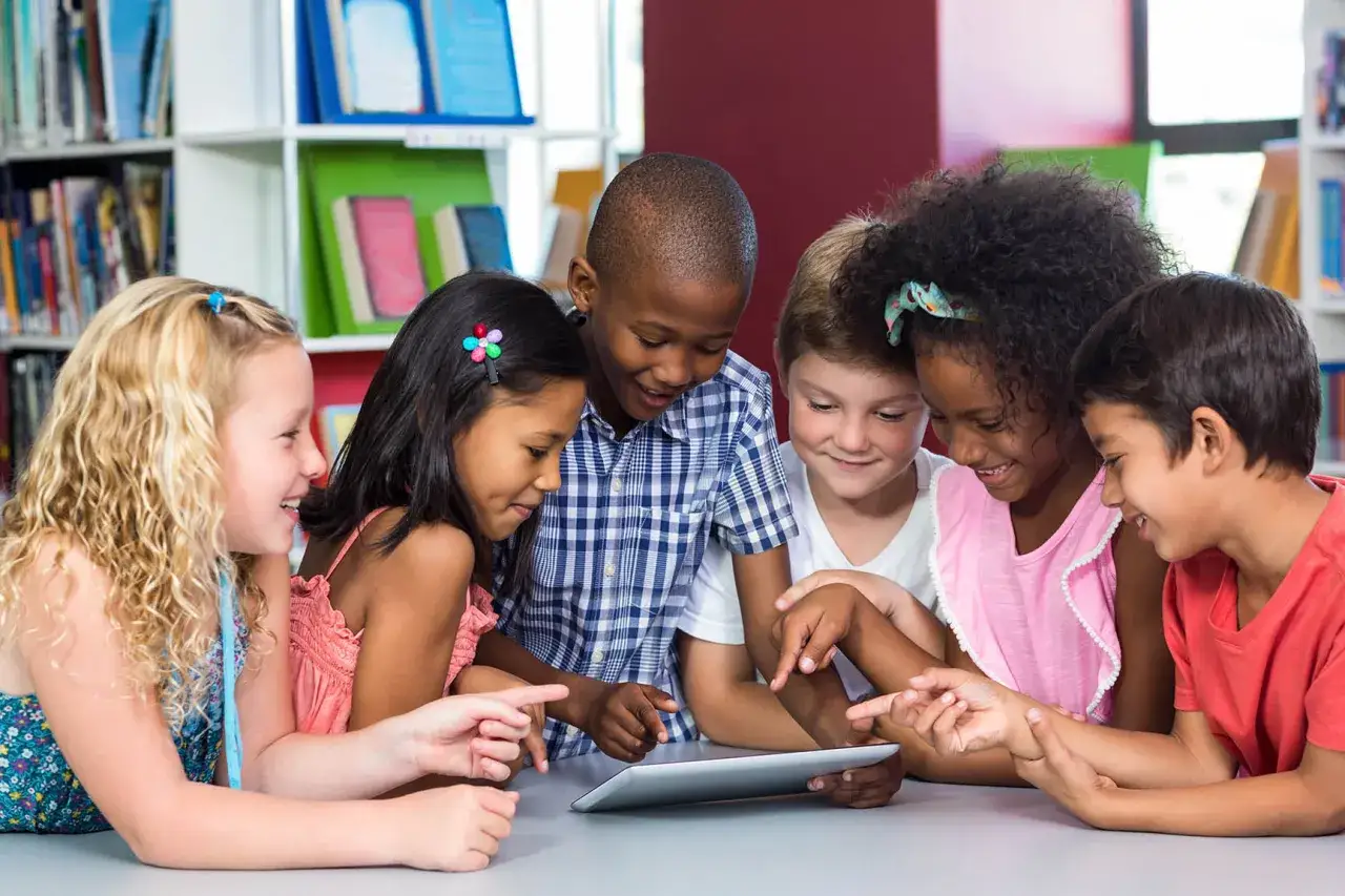 Kinder lernen gemeinsam mit einem Tablet. Diese Methodenvielfalt im Unterricht f&ouml;rdert das kollaborative Arbeiten und den Wissensaustausch.
