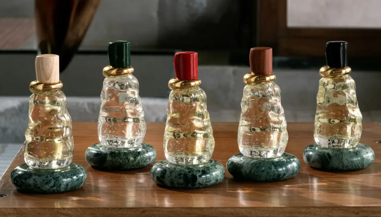 Pięć flakonów perfum Bottega Veneta 75ml z kamiennymi podstawkami i złotymi pierścieniami.