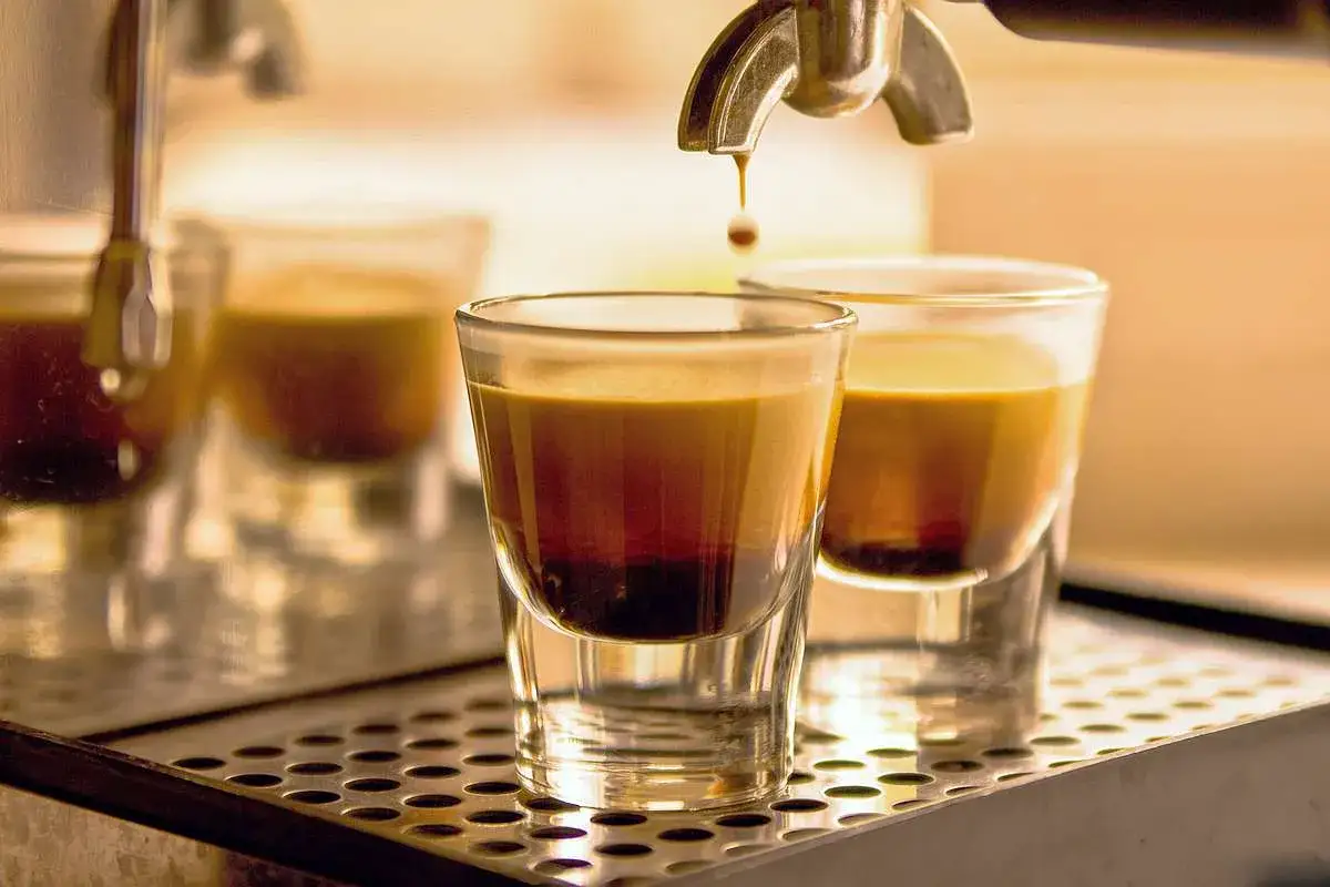 Kropla kawy spada do szklanki z aromatycznym espresso. To właśnie espresso, esencja kawy, przygotowywana pod ciśnieniem.