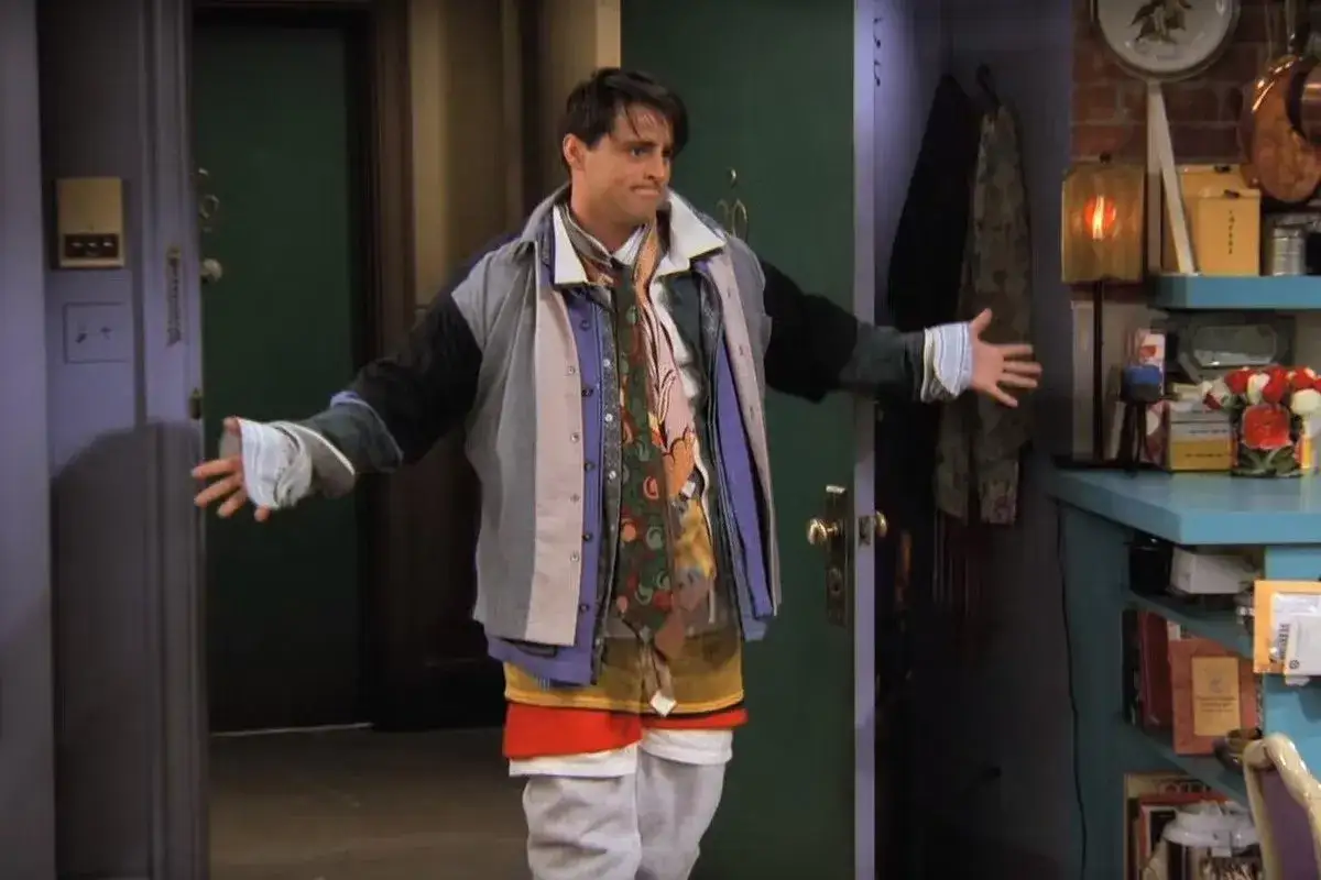 Joey w ubraniu na cebulkę, z wieloma warstwami koszul i krawatów, prezentuje swój nietypowy styl.