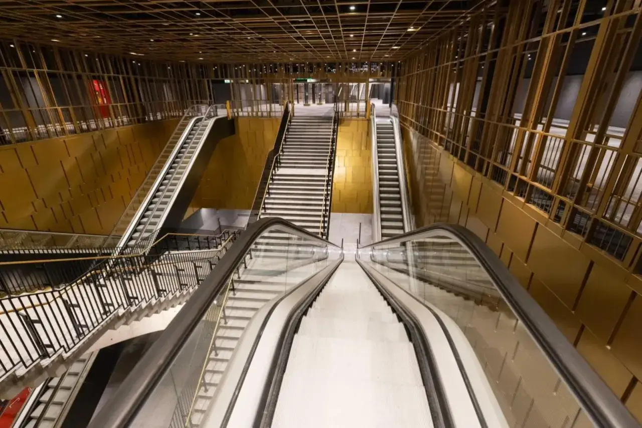 Moderna stazione della **Cavour Roma metro** con scale mobili e gradinate dorate.
