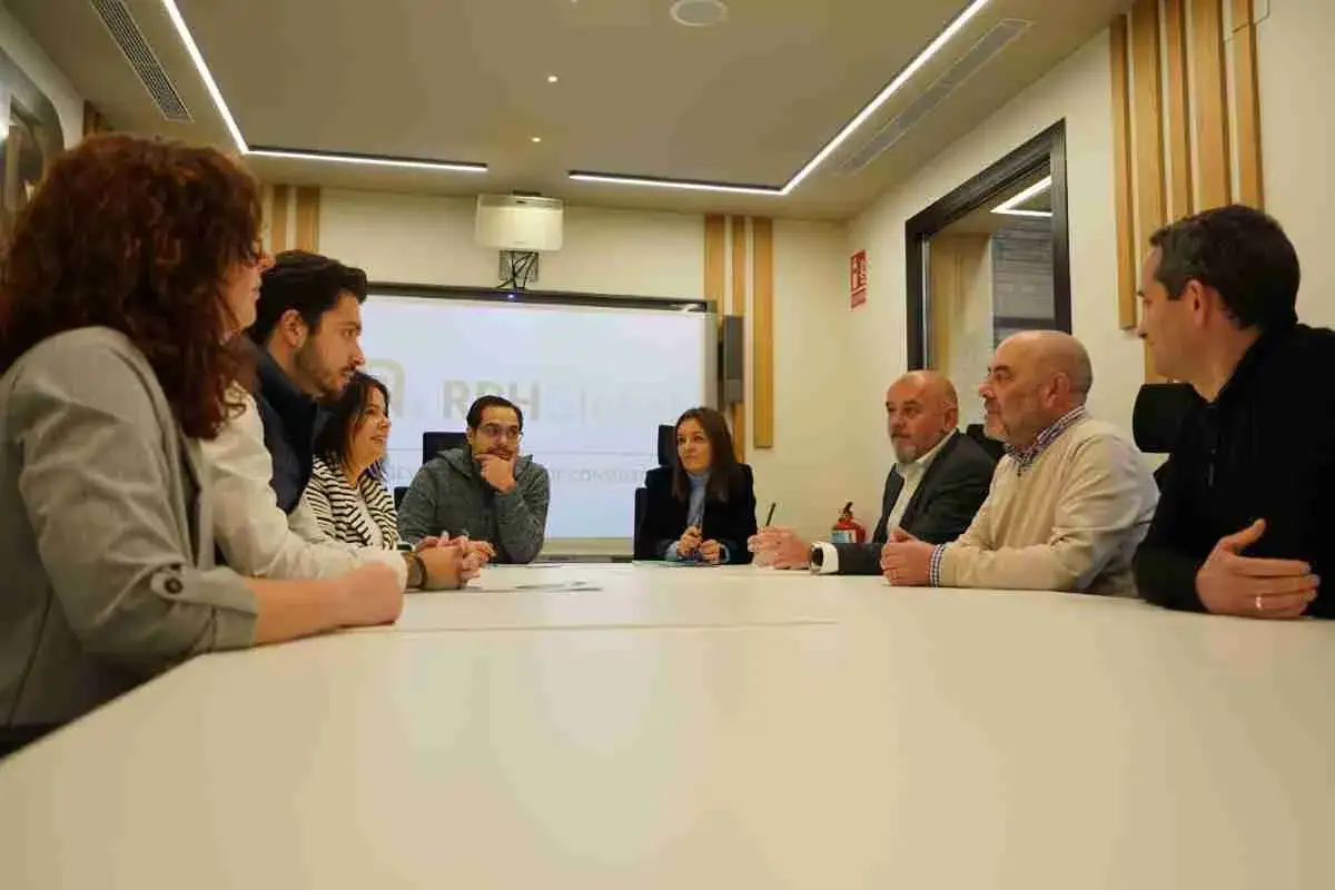 Un equipo discute estrategias en una sala de reuniones, demostrando c&oacute;mo funciona una asesor&iacute;a.