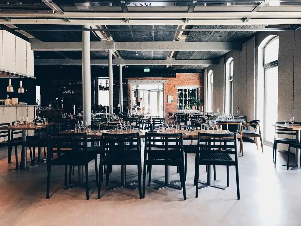 Väl dukade bord med glas och bestick i en modern restauranglokal. Kanske en plats för att njuta av god mat på the picts bar.