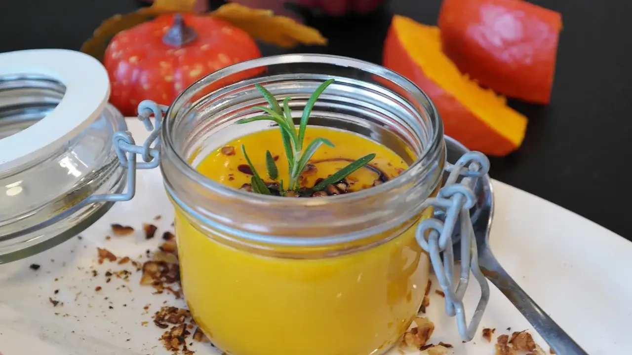 Kürbissuppe im Weckglas, garniert mit Rosmarin und Nüssen. Perfekt für die Herbstzeit, die einkochzeiten tabelle weck hilft bei der Zubereitung.