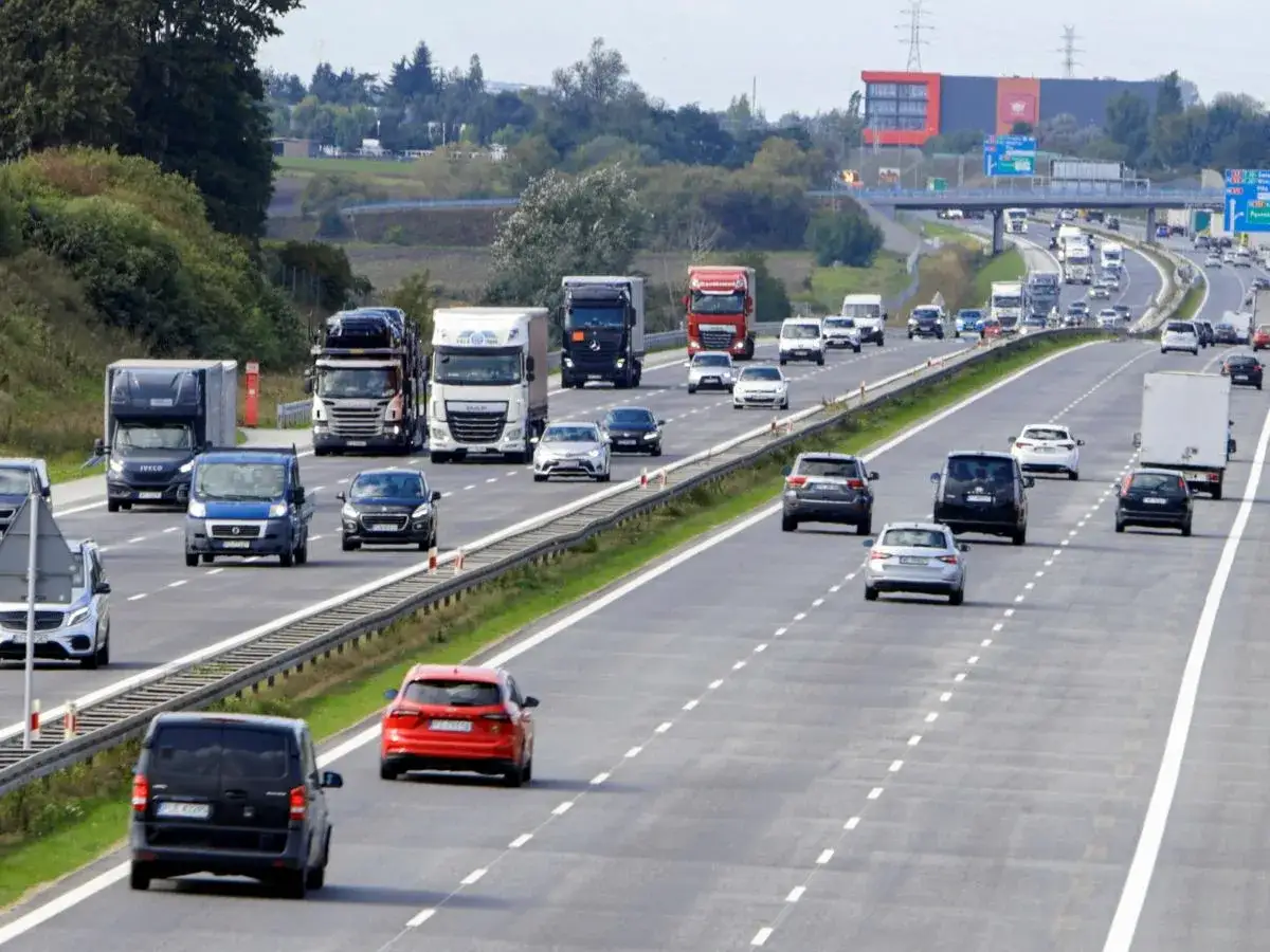 Intensywny ruch na autostradzie, gdzie samochody i ciężarówki stosują jazda na suwak, by płynnie włączyć się do ruchu.