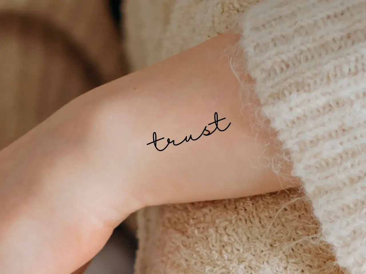 Ein zartes Tattoo mit dem Wort 