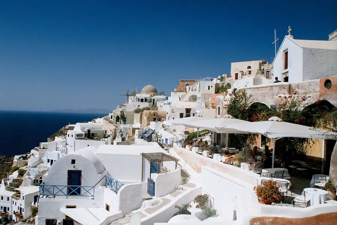 Santorini co zobaczyć: białe domy na klifie, wiatrak, kości&oacute;łek i kawiarnie z widokiem na morze.
