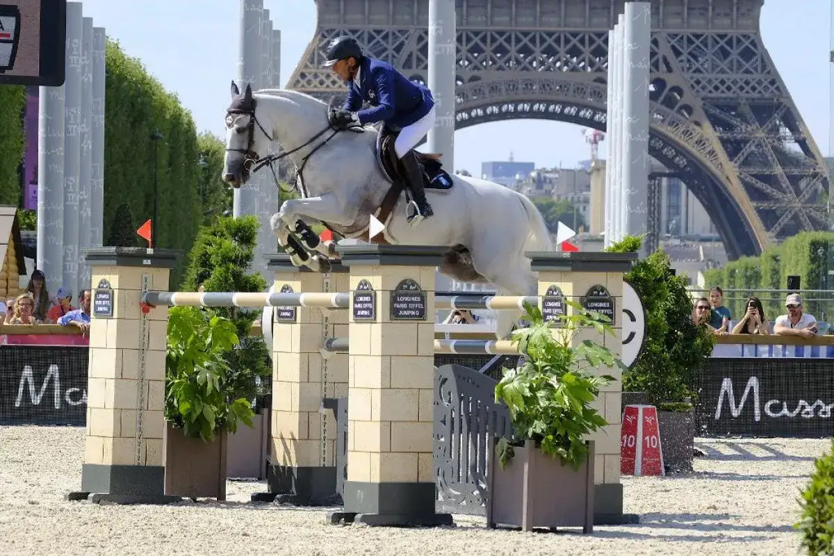 Un cavalier et son cheval blanc, peut-&ecirc;tre Rahotep de Toscane, franchissent un obstacle &agrave; Paris, avec la Tour Eiffel en arri&egrave;re-plan.