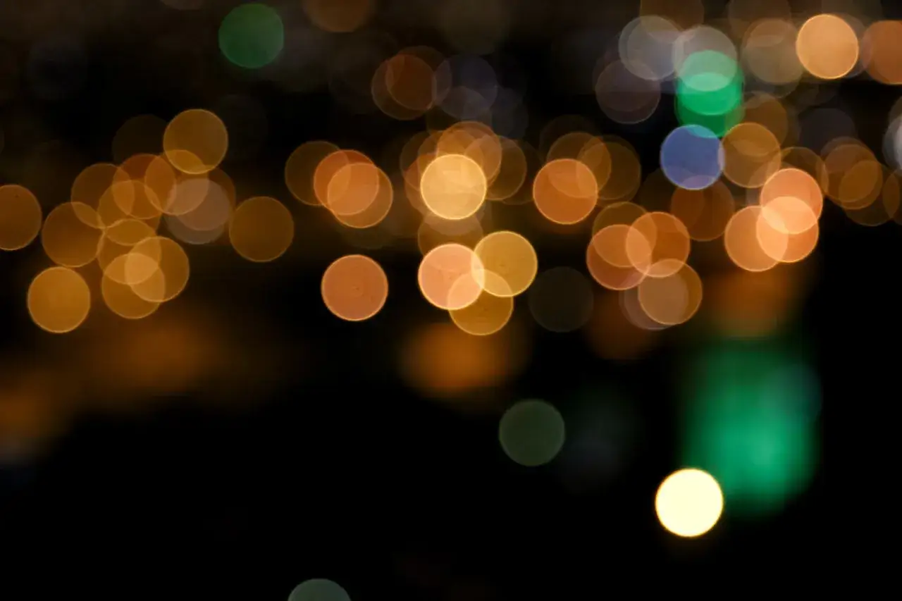 Golden bokeh lights dance against a dark background, creating a dreamy, no blur effect.
