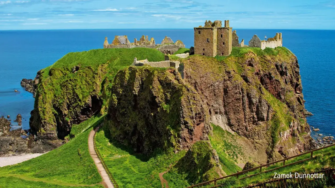Ruiny zamku na klifie nad morzem. Ten zamek Szkocja, Dunnottar, wygląda majestatycznie na tle błękitnego nieba i oceanu.