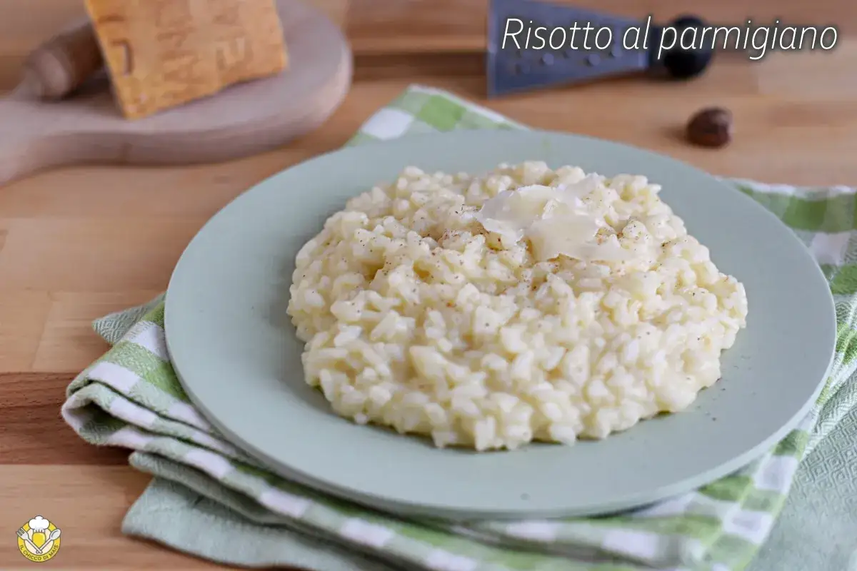 Un cremoso risotto alla parmigiana, guarnito con scaglie di formaggio, pronto per essere gustato.