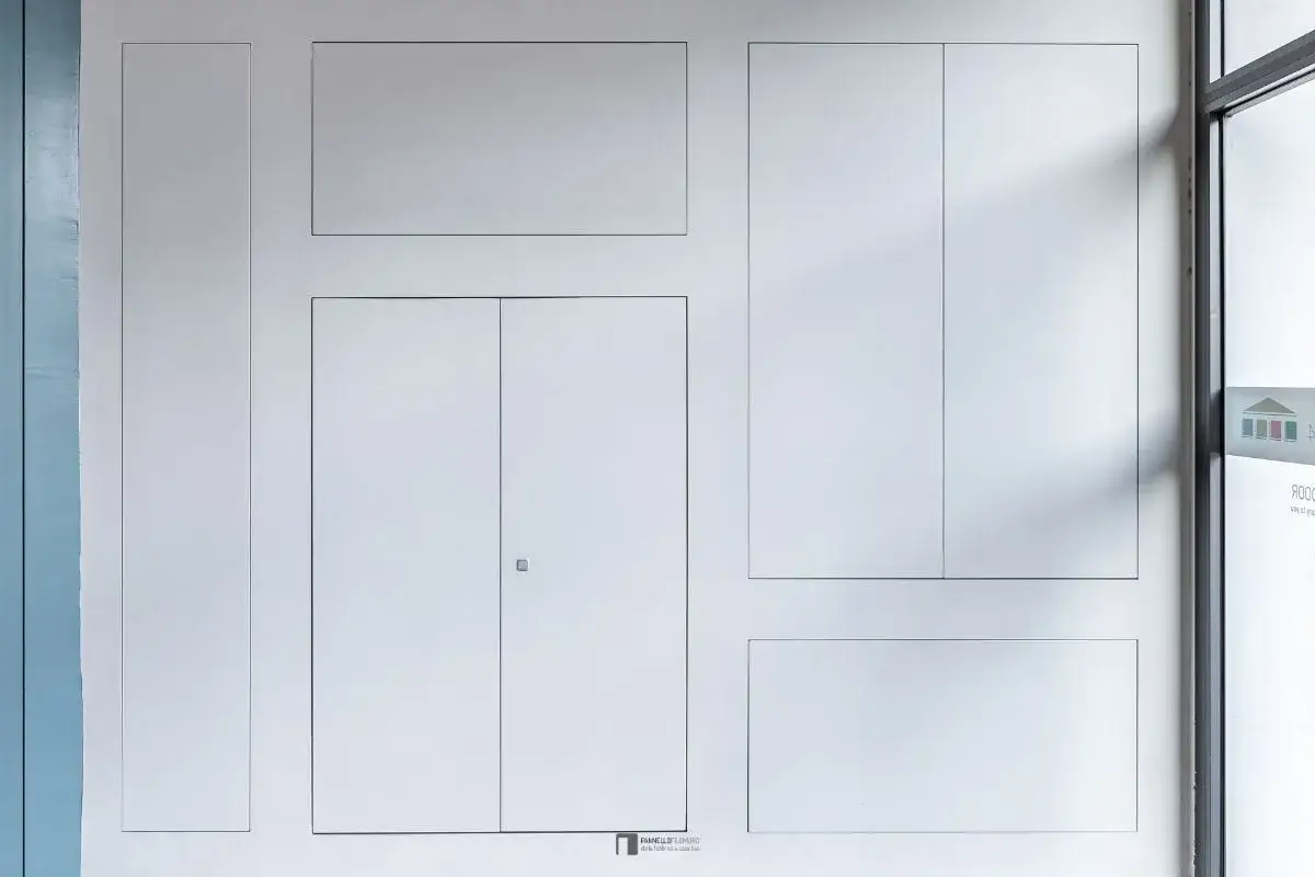 Parete con diverse ante per nicchie in cartongesso, alcune a battente, altre a filo muro, per un design minimalista e integrato.