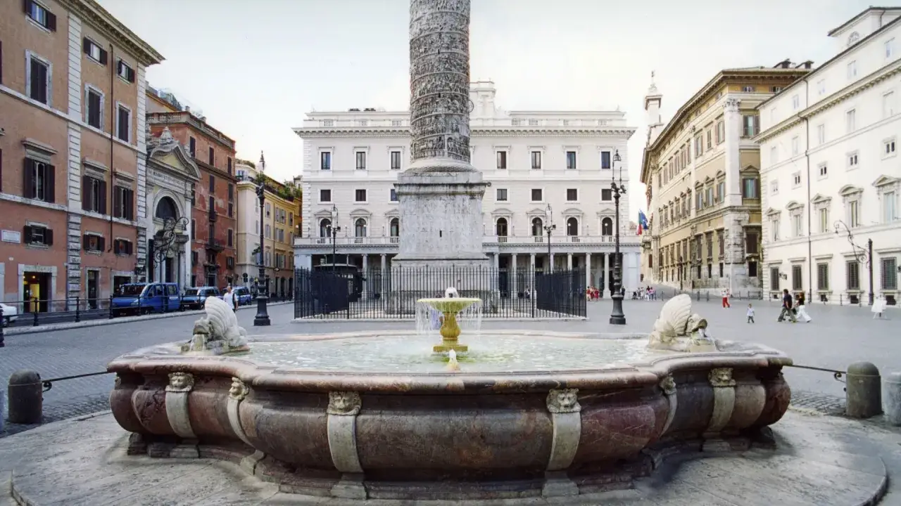 Fontana barocca e la Colonna di Marco Aurelio in Piazza Colonna, Roma.
