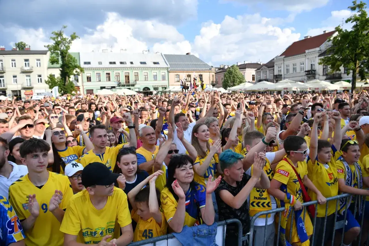 Tłum kibic&oacute;w w ż&oacute;łtych koszulkach świętuje na zewnątrz, wspierając swoją drużynę w lidze europy piłka ręczna.