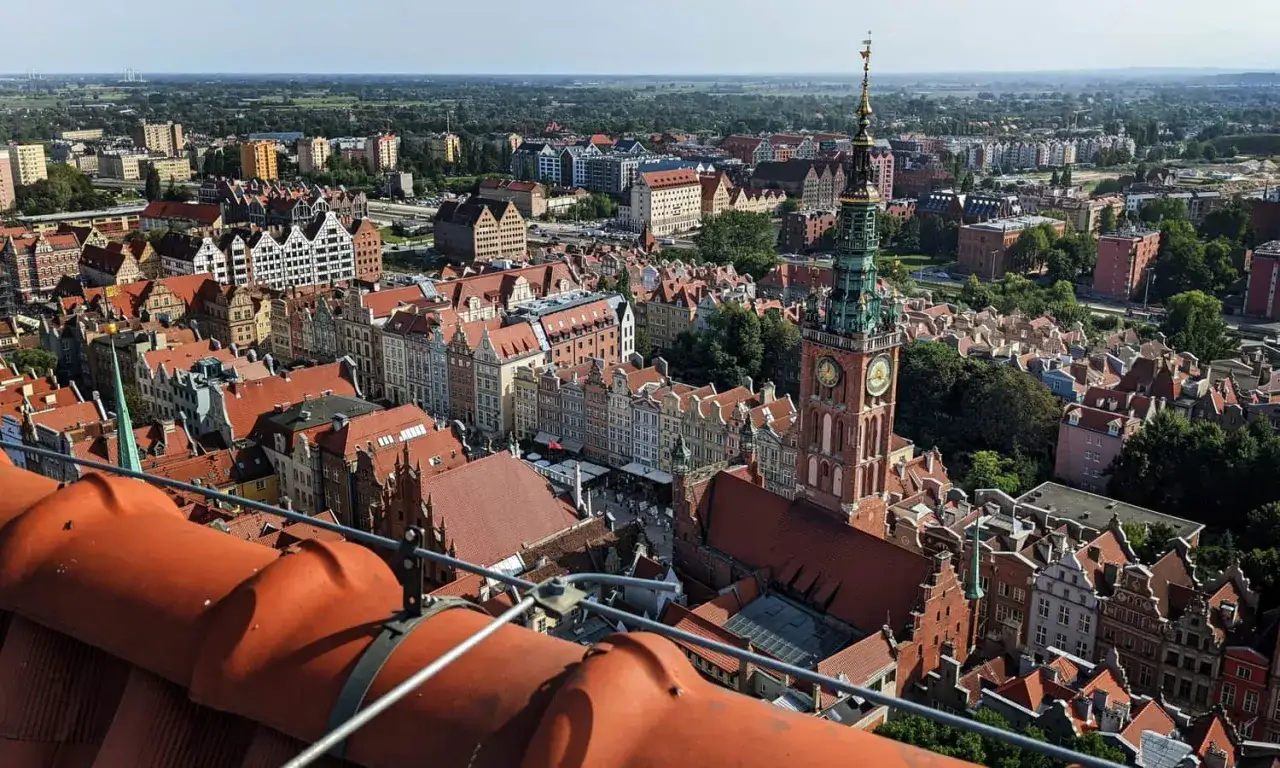 Widok na Gdańsk z lotu ptaka. Wieża Ratusza Głównego Miasta i zabytkowe kamienice ukazują bogactwo gdańskich atrakcji turystycznych.