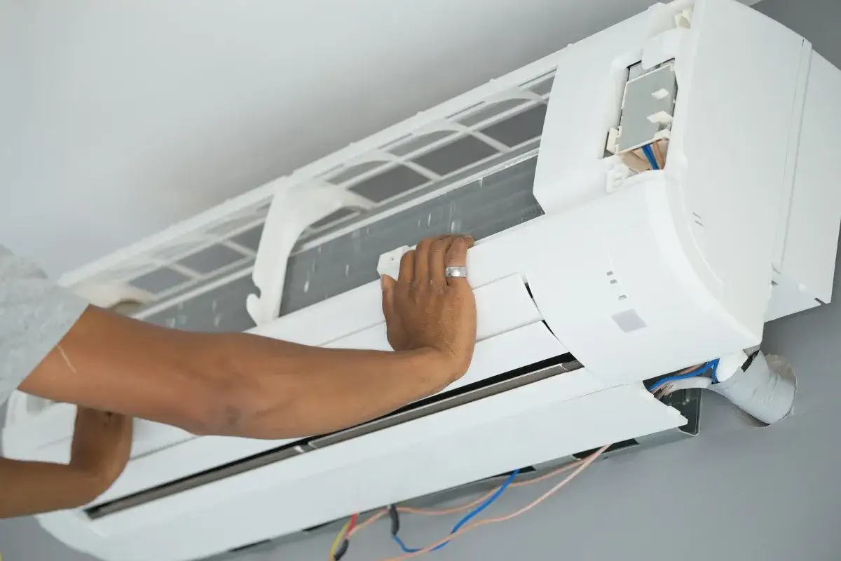 Mano ajustando el cepillo para limpiar la turbina del aire acondicionado.