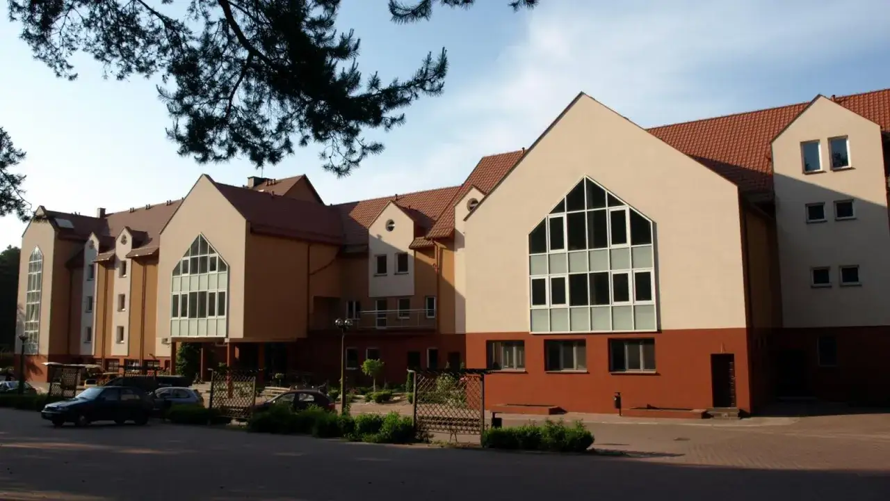 Nowy budynek o ciekawej architekturze, przypominającej kształtem bocheniec chleba, z dużymi oknami i brązowo-beżową elewacją.