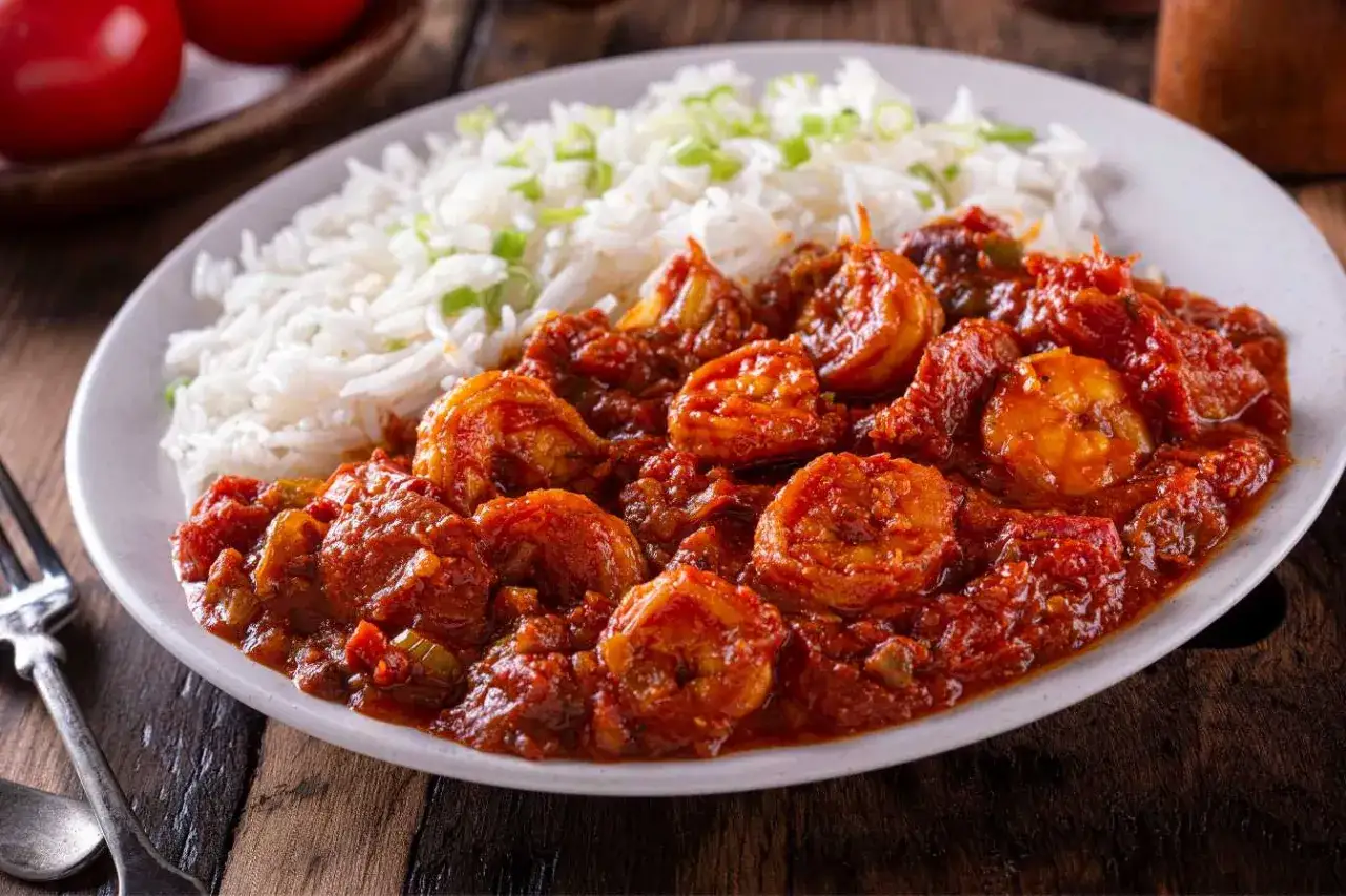 Crevettes en sauce tomate épicée, accompagnées de riz blanc. Un plat qui rappelle le boudin rouge antillais par sa richesse.