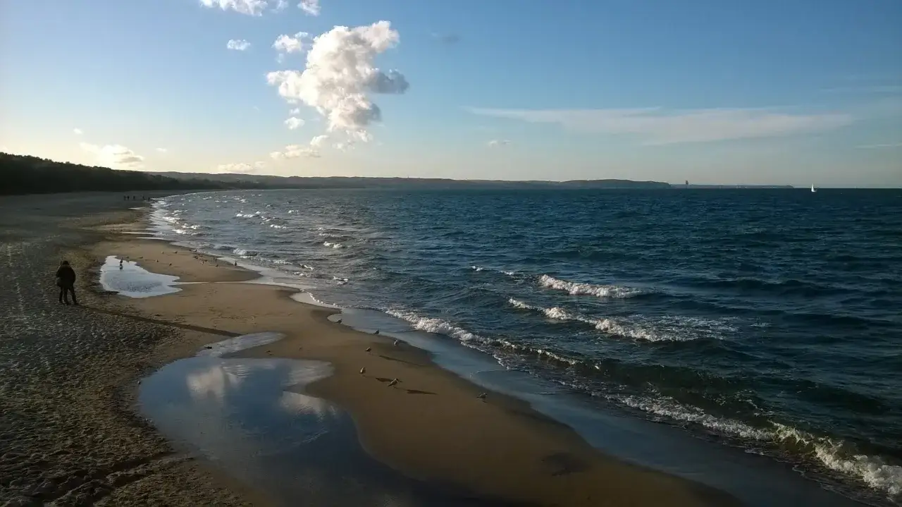 Plaża w Gdańsku, w pobliżu Novotel Gdańsk Marina. Spokojne morze, piasek i pojedyncze mewy.