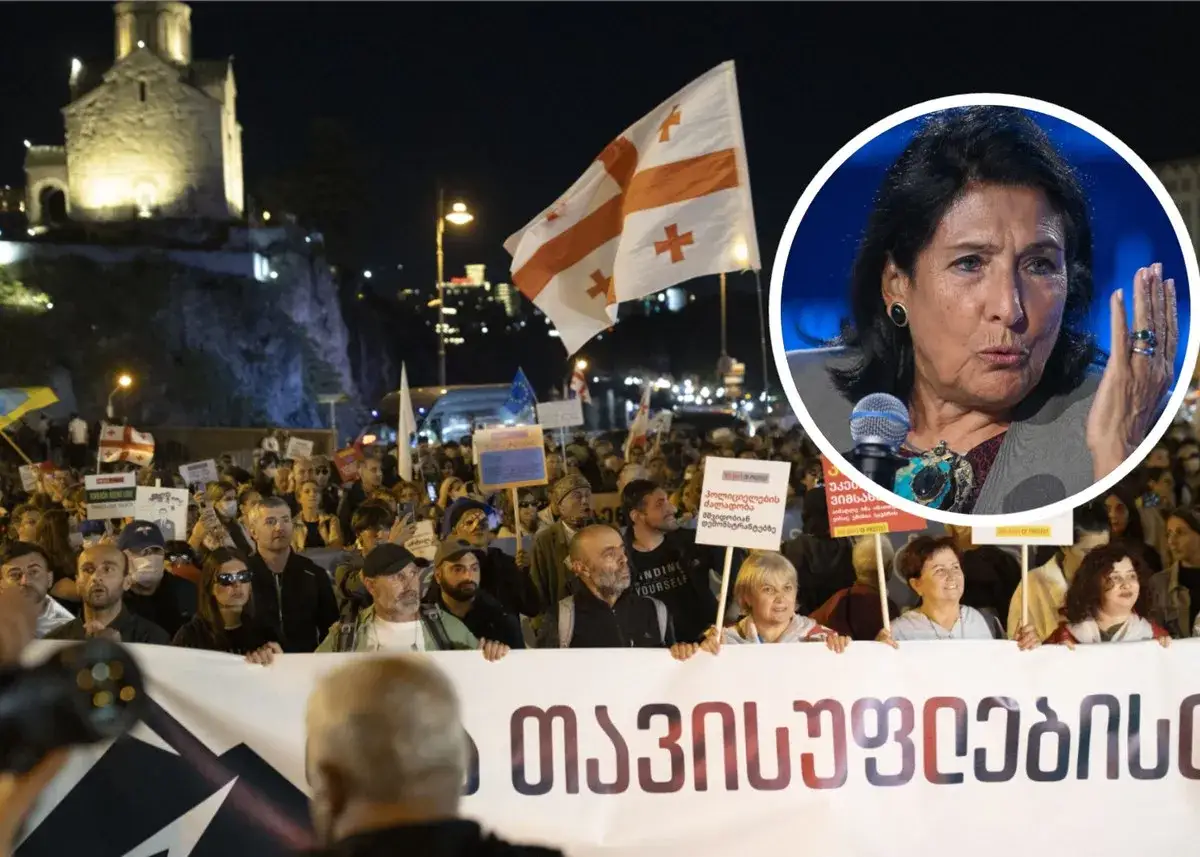 Protest w Tbilisi. Ludzie z gruzińskimi flagami i transparentami wyrażają swoje zdanie na temat sytuacji politycznej. W tle prezydent Gruzji.