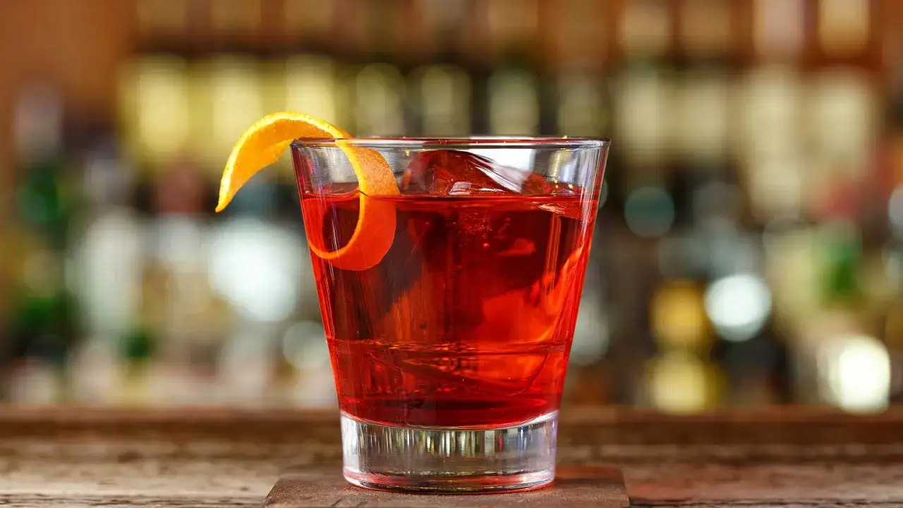 Klasyczny negroni przepis: czerwony, orzeźwiający koktajl z pomarańczą i lodem, idealny na wieczór.